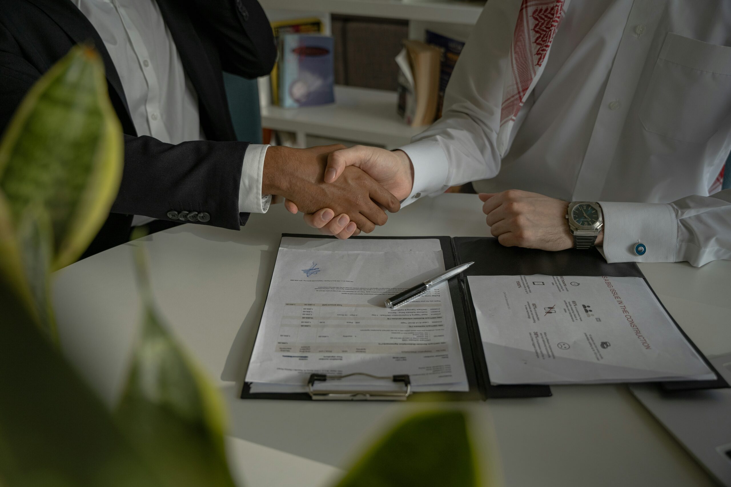 Two men shaking hands over a contract